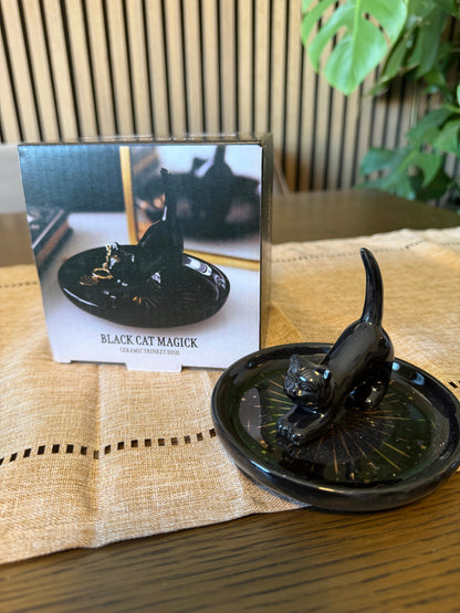 Glossy black ceramic trinket dish with sculpted black cat figure and celestial star detailing, shown with gift box